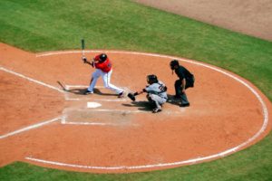 Picture of baseball player swinging with catcher and umpire behind him