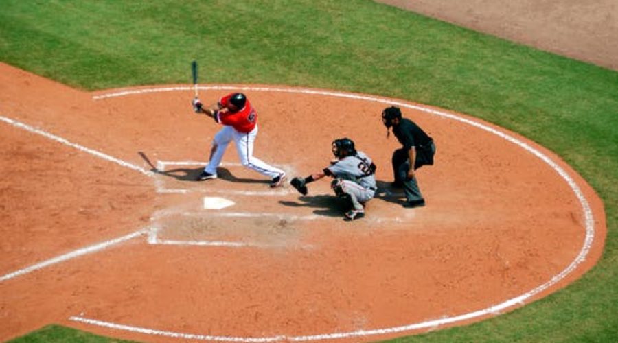 Picture of baseball player swinging with catcher and umpire behind him